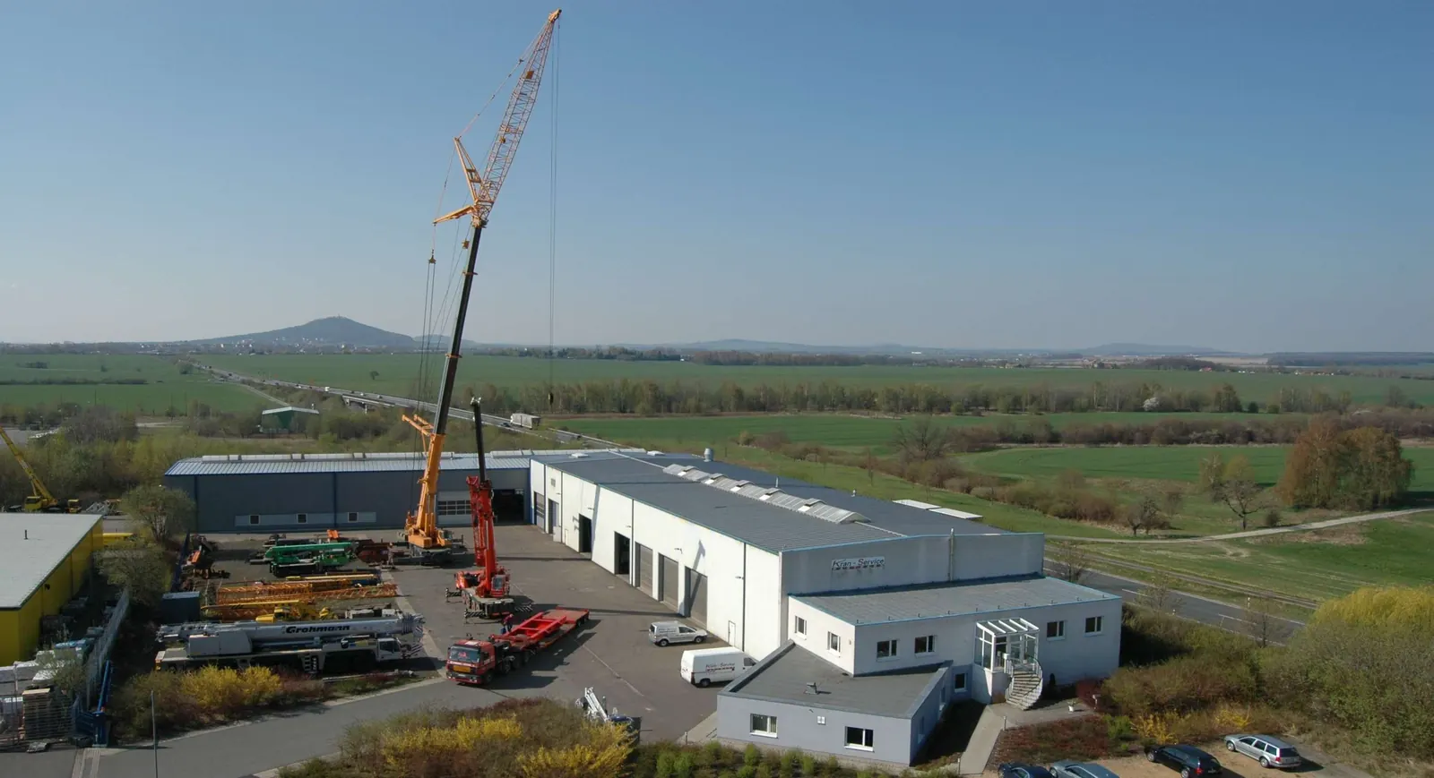 Firmengelände der Kran-Service Hartmann GmbH in Görlitz mit Werkhallen und Autokranen